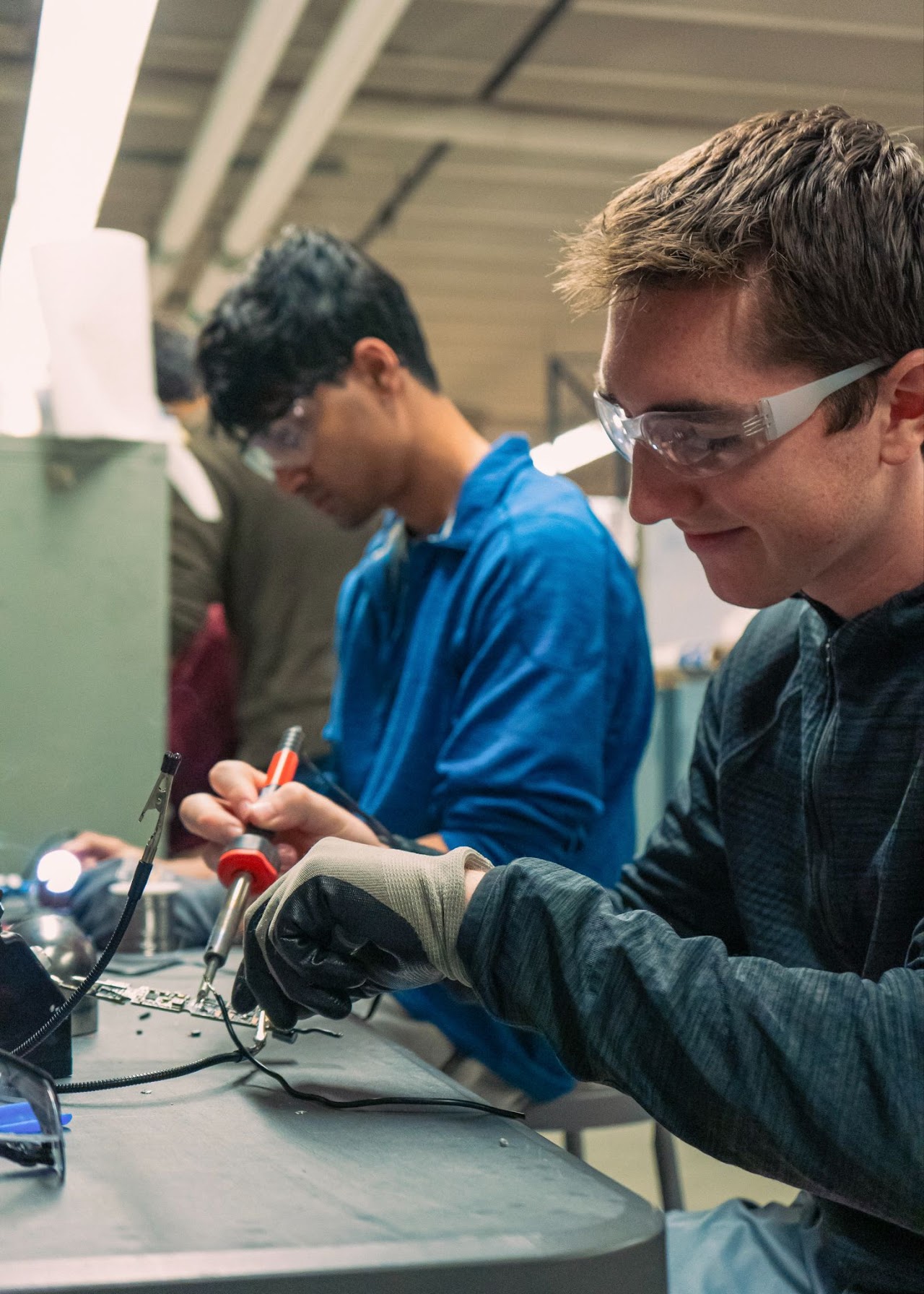Two members using soldering iron